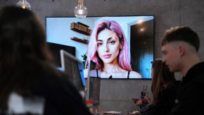 Образ на модела Айтана Лопес, генериран от изкуствен интелект, показан на екран в централата на компанията The Clueless © AFP / PAU BARRENA