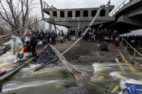 Местни жители преминават по разрушен мост, докато се евакуират от град Ирпин, след като в продължение на дни местното население е обстрелвано по единствения път за бягство, докато руските войски настъпват към столицата, в Ирпин, близо до Киев, Украйна, 7 март.