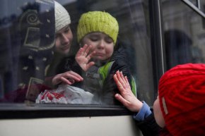 Александра, на 12 г. , държи сестра си Еся, на 6 г. , която плаче, докато маха на майка си Ирина, докато членове на еврейската общност в Одеса се качват на автобус, за да избягат от руската инвазия в Украйна, в Одеса, Украйна, 7 март. 