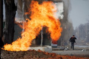 Мъж минава покрай горящ газопровод, който е бил ударен по време на обстрел от руски позиции в квартал в северната част на Харков, Украйна, 31 март 2022 г. REUTERS/Thomas Peter
