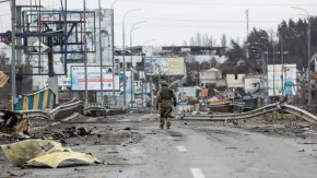 Украински войник минава покрай трупове на разрушен път в Буча, Киевска област. ©Mykhaylo Palinchak / SOPA Images / LightRocket via Getty Images