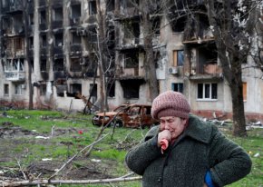 71-годишната местна жителка Тамара плаче пред разрушената жилищна сграда в Мариупол във вторник. (Александър Ермоченко/Reuters)