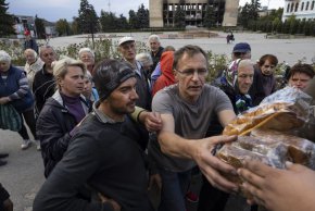 На 20 септември в Изиум, Украйна, жителите взимат хляб, докато местната хуманитарна организация "Добър хляб" им го раздава. (Паула Бронщайн /Getty Images)