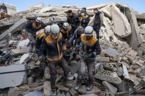 Членове на сирийската гражданска защита, известни като "Белите каски", изнасят жертва от развалините на сгради в село Азмарин в контролираната от бунтовниците северозападна провинция Идлиб на 7 февруари. (Omar Haj Kadour/AFP/Getty Images)