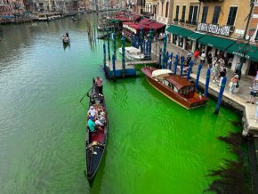Гондола пресича историческия канал Гранде във Венеция, докато в него се разпространява фосфоресцираща зелена течност, неделя, 28 май 2023 г.
