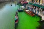 Гондола пресича историческия канал Гранде във Венеция, докато в него се разпространява фосфоресцираща зелена течност, неделя, 28 май 2023 г.