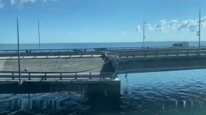 Лодка плава до Кримския мост, който свързва Русия с полуострова през Керченския проток, в Крим, на 17 юли. Стрингер/Ройтерс