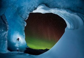 
Една от новите му снимки показва катерач на дъгообразна ледена стена, на която полярното сияние блести в лилаво и зелено сред множество ярки звезди.